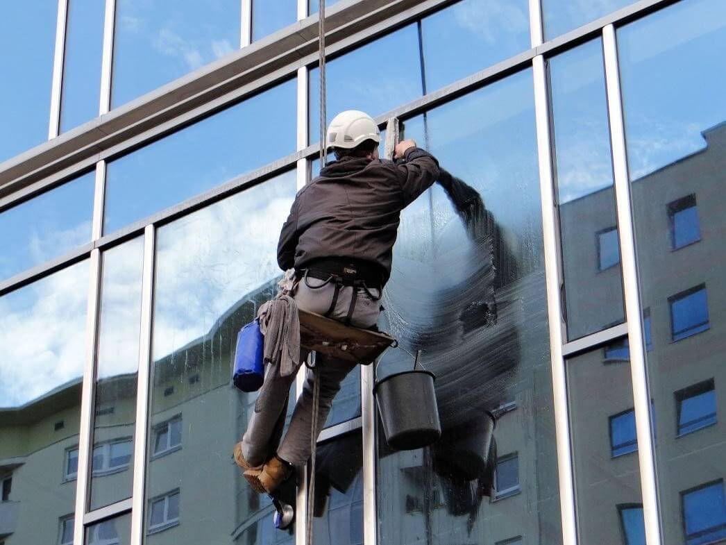 Emmanuel & CO Cleaning staff member performing professional window cleaning at a Sandton property