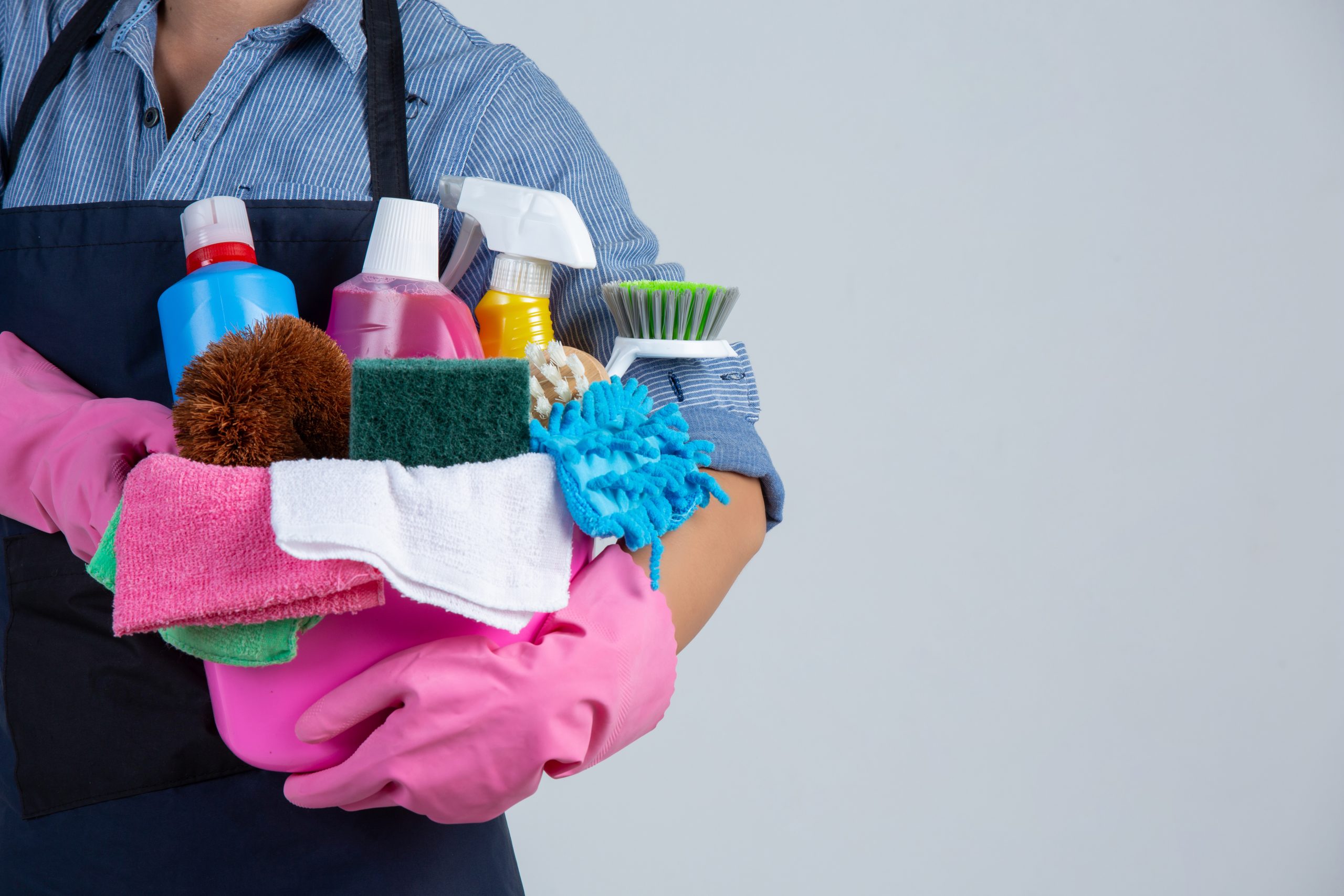 woman is holding cleaning product gloves rags basin white wall scaled -Professional Cleaning Services in Johannesburg